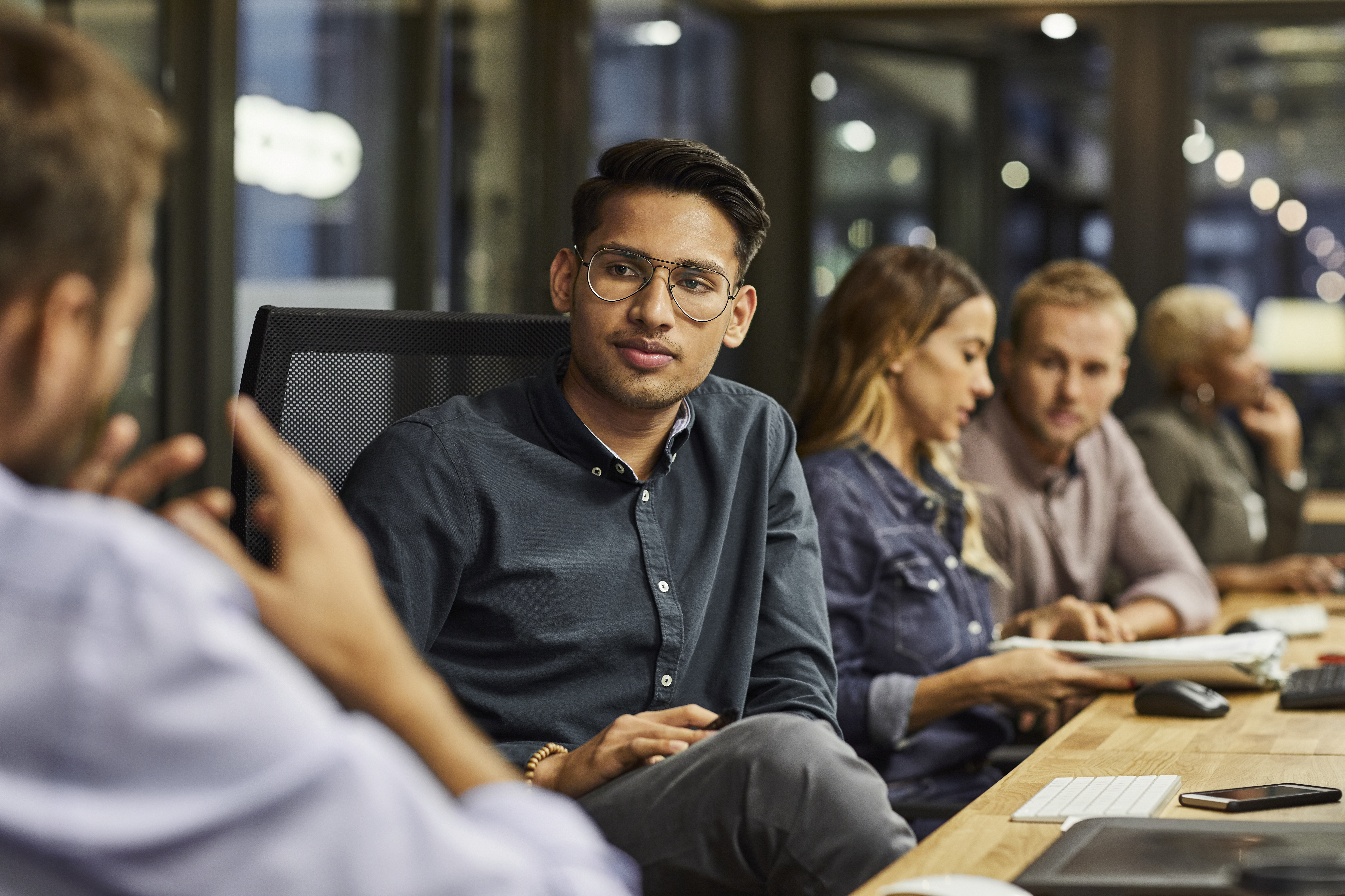 Man sitting and looking toward colleague