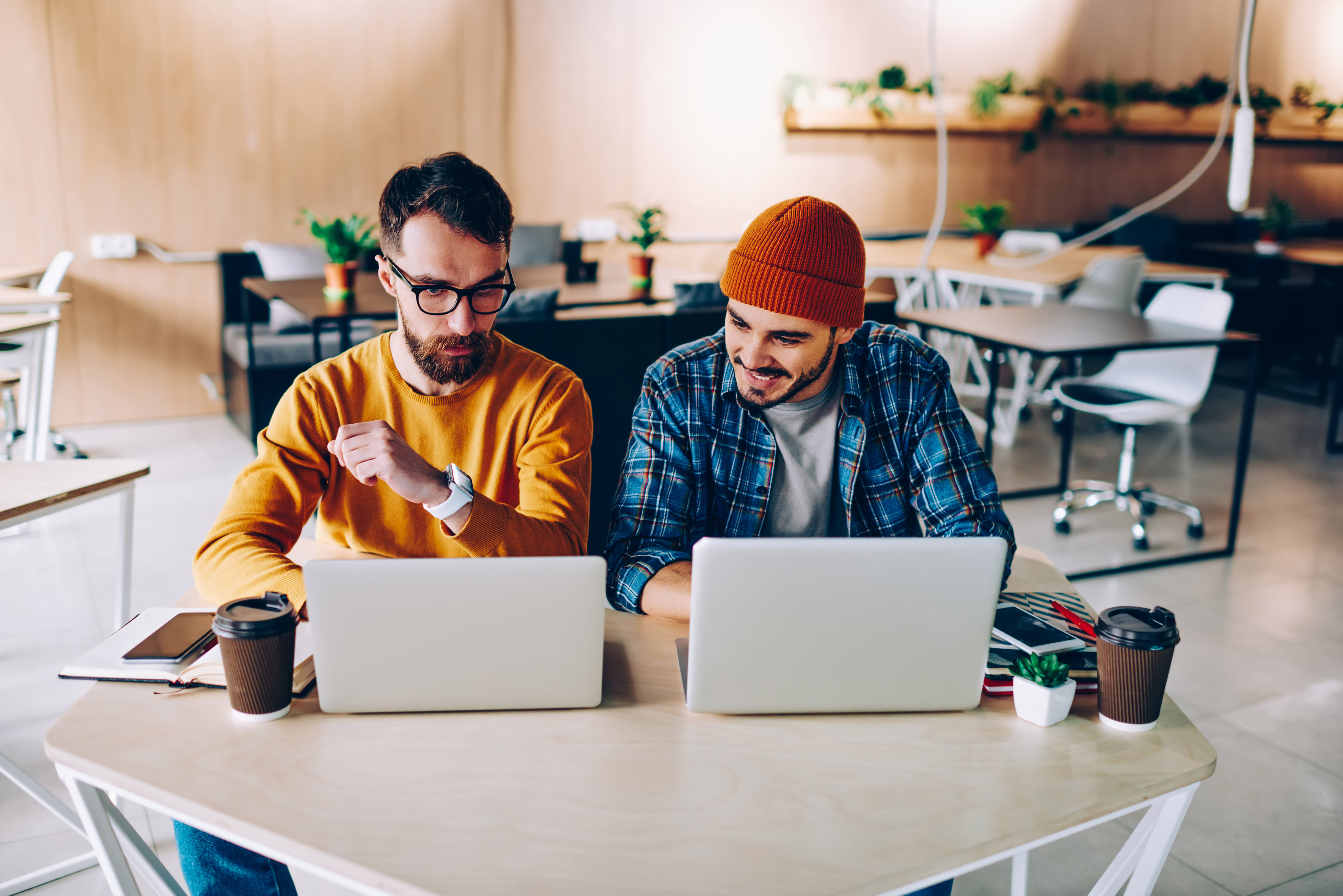 Two men looking at laptops