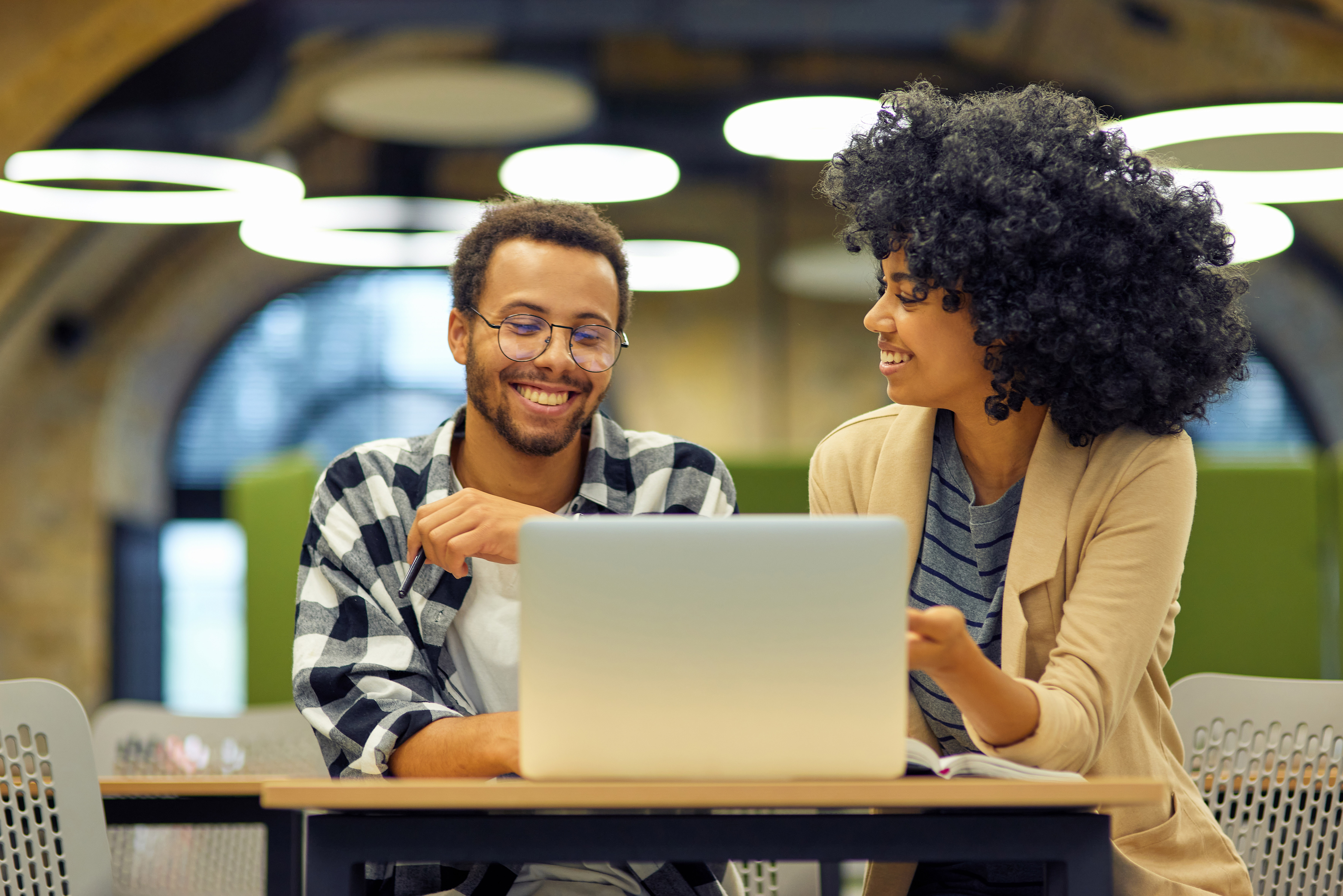 Two people smiling with laptop
