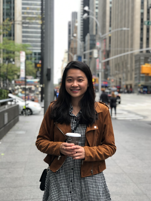 Photo of Christine Huang smiling while holding coffee