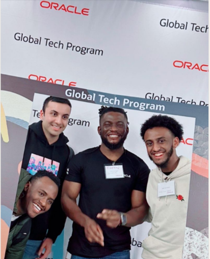 Group of employees in front of Oracle Global Tech Program sign
