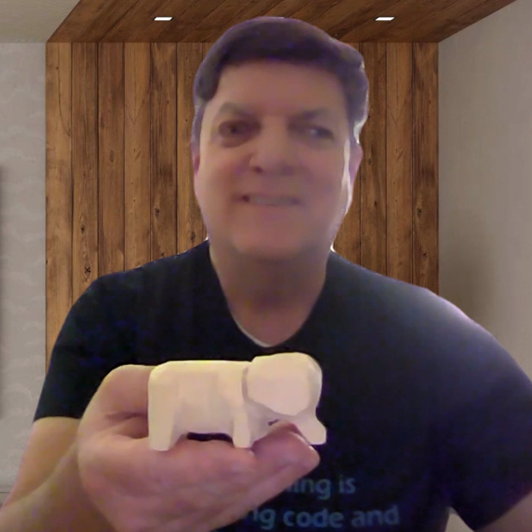 Don Raikes holding his wood carving