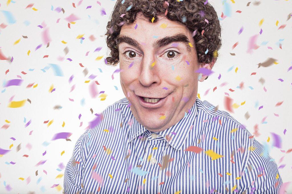 Smiling man showered in confetti
