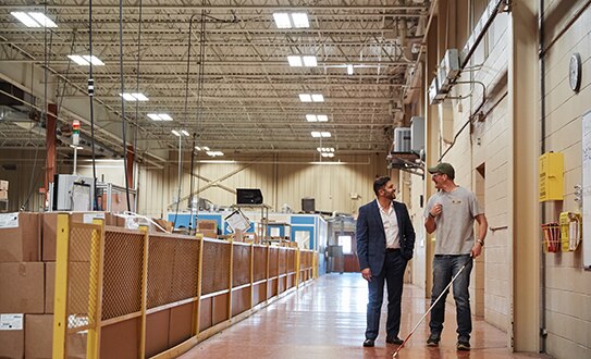 IBVI Chief Innovation Officer Emmanuel Vouvakis, left, chats with employee Justin Greenwood at the manufacturing facility.