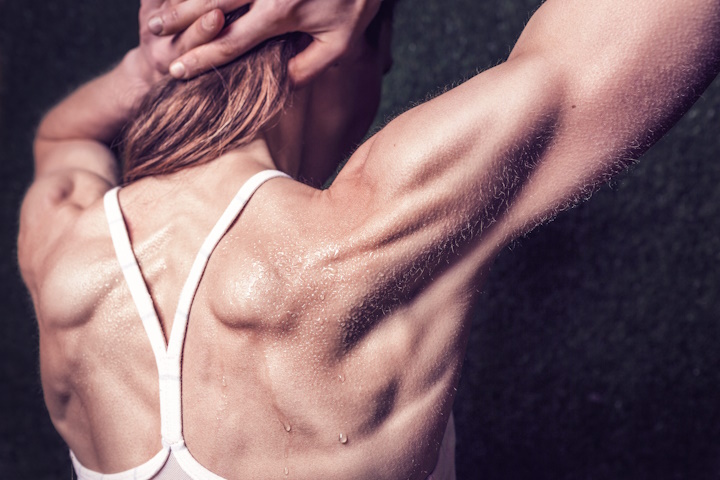A persons back with arms pulling hair back after training