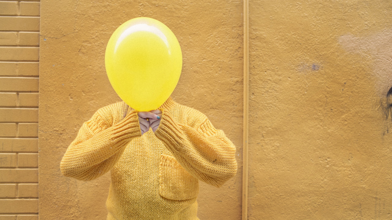 Person with balloon covering their face