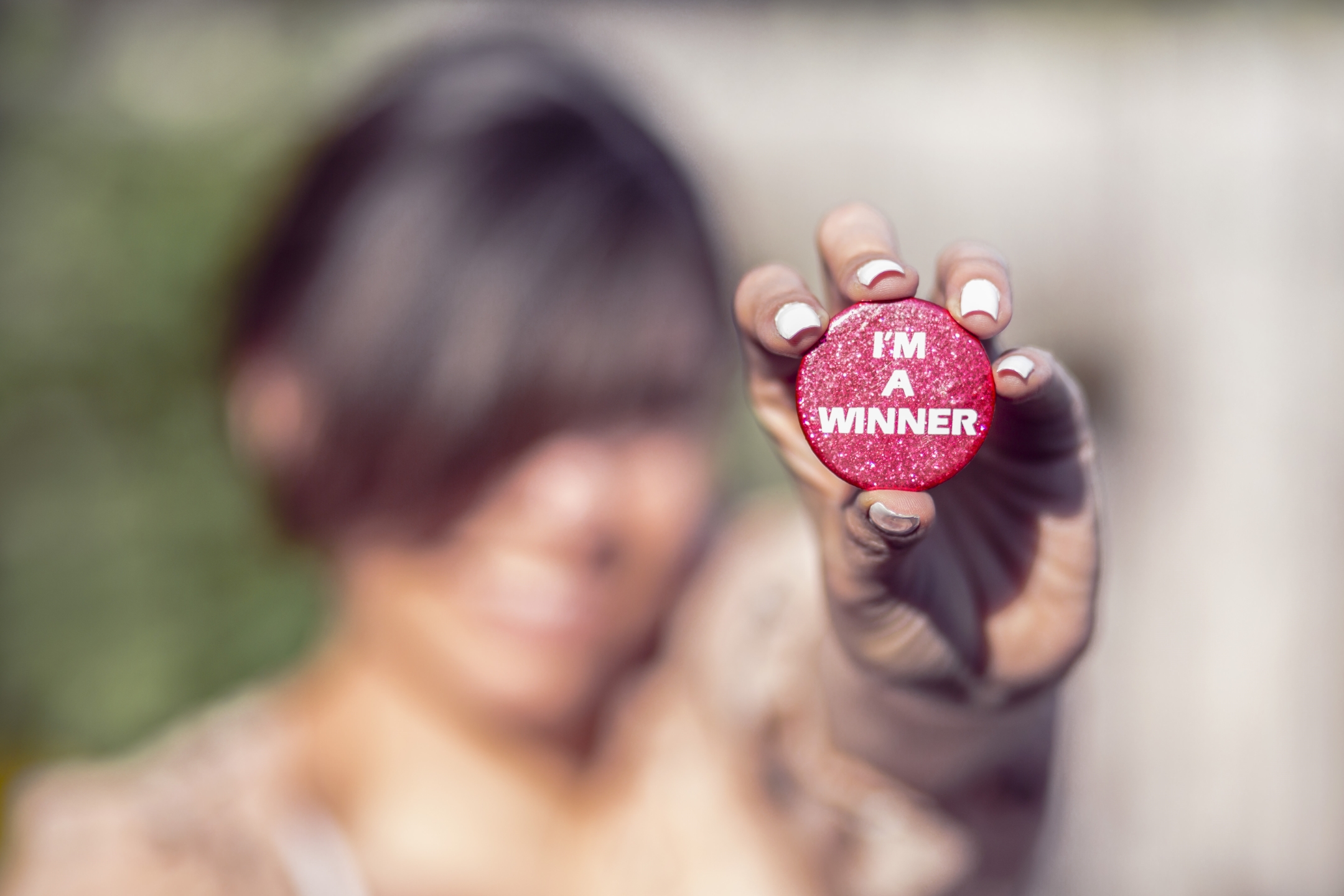 Person holding "I'm a winner" badge