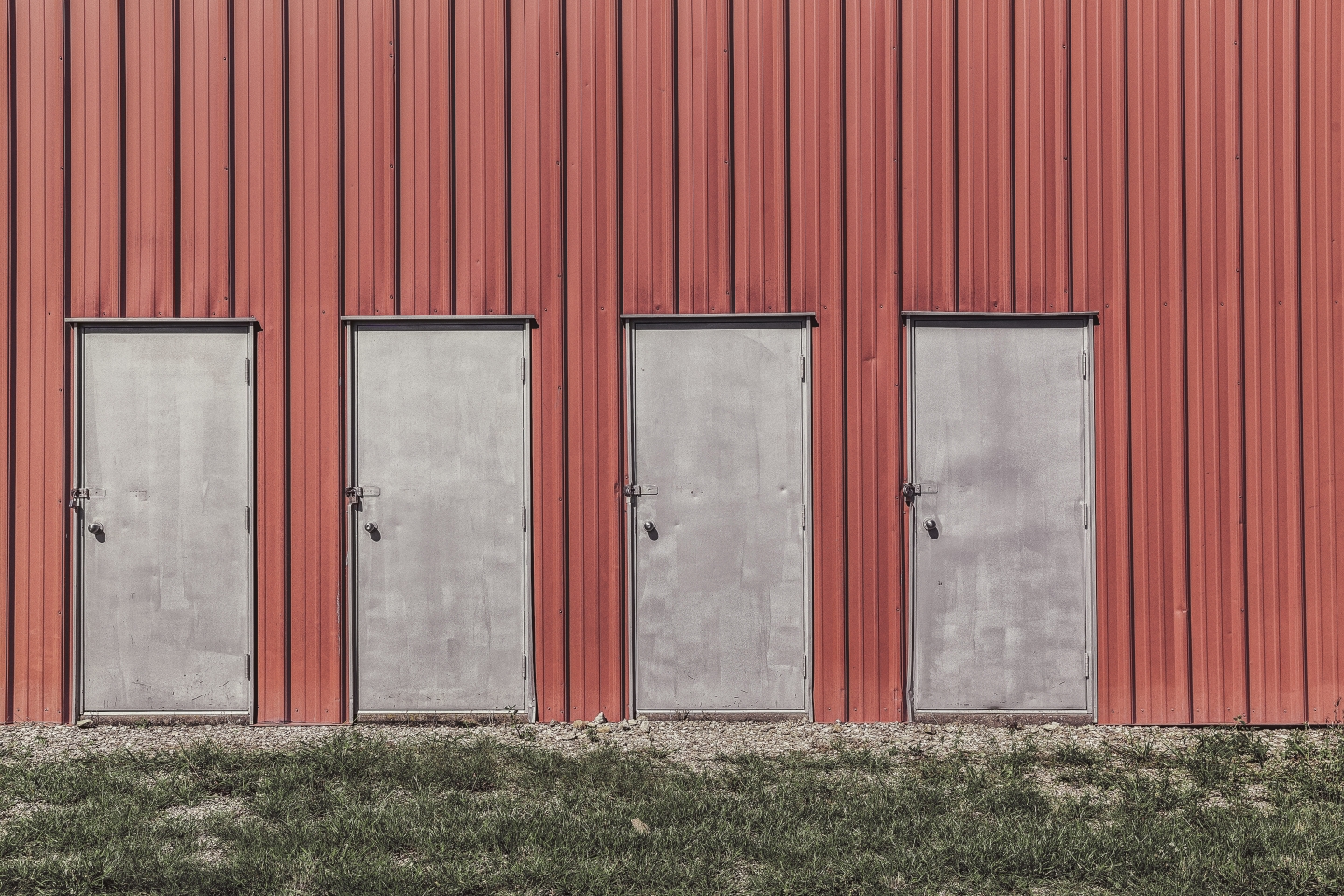 Four metal doors on a red wall