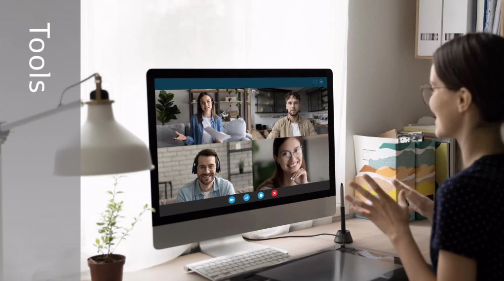 Woman looking at computer screen with four people on the screen one in each box