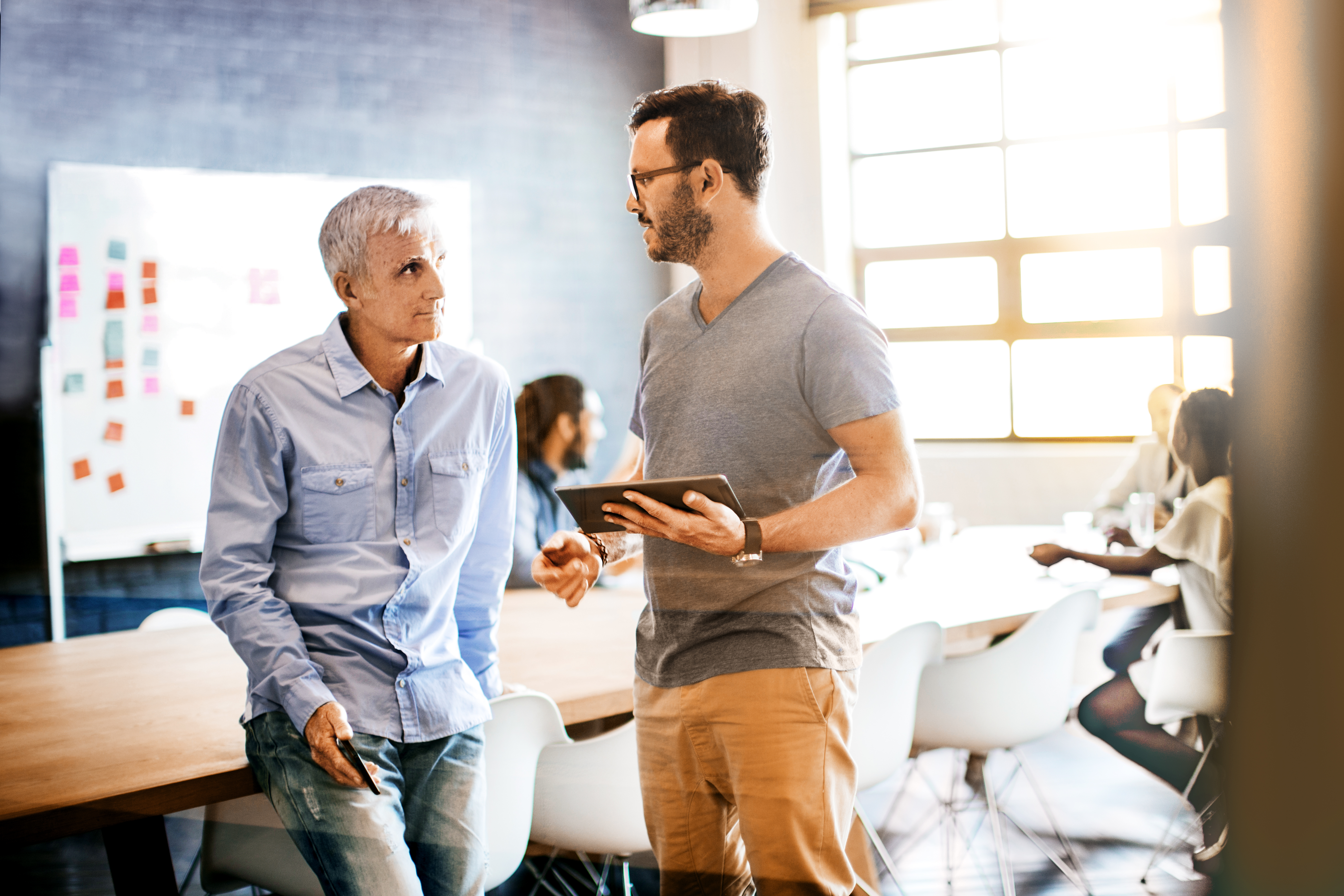 two men talking in a conference room