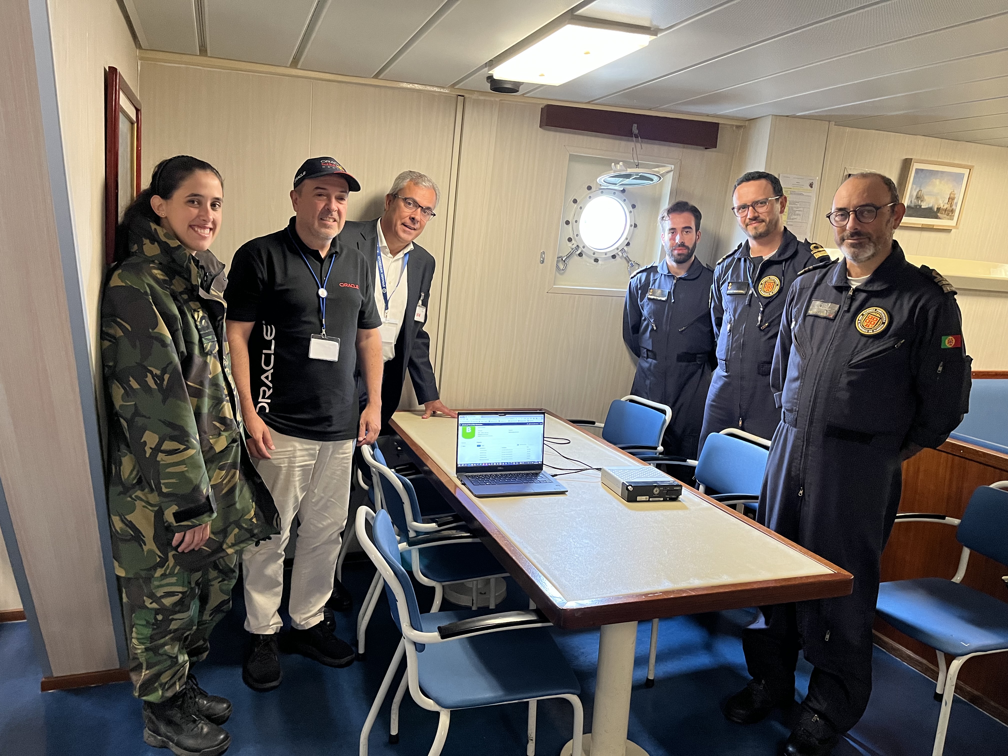 A photo of five people standing around a table with a laptop and an Oracle Roving Edge Ultra.