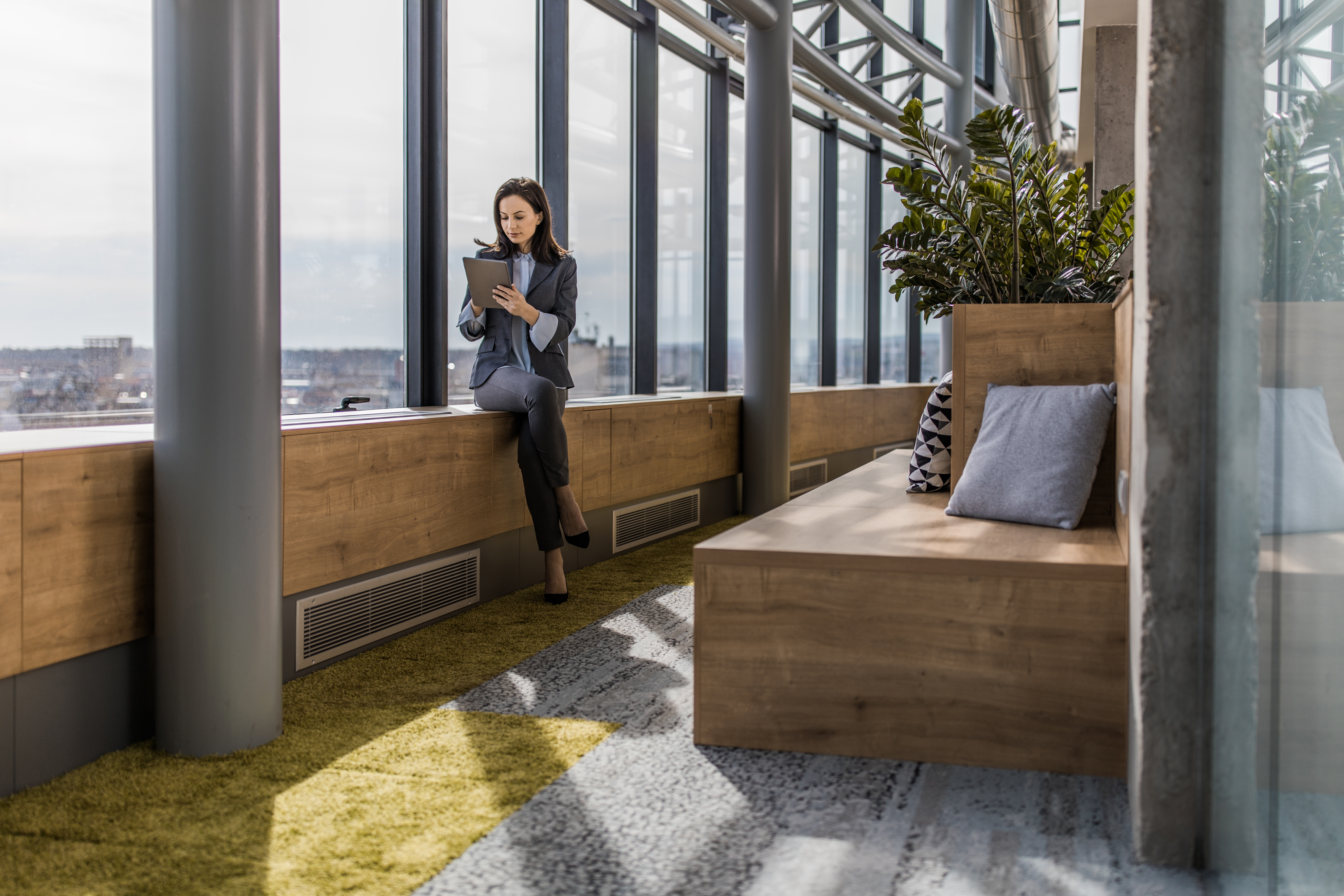 Woman looking at tablet next to window